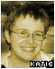 A person with short dark hair and glasses smiles in a pixelated image with the text KATIE at the bottom.