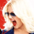 A pixelated close-up of a person with light hair wearing dark sunglasses, red lipstick, and a dark blue top against a red and white background.