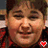 A pixelated image shows a person with short brown hair wearing a red and black checkered shirt, with a small red heart symbol on the chest.