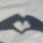 A static pixelated image shows a heart shape formed by two dark curved lines against a light gray background.