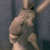 A pixelated figure in a light-colored outfit with arms raised against a dark blue background.