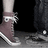 A static image shows two feet wearing sneakers on a textured surface, with text below reading "Love" and "Converse".