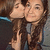 Two people in a close-up pose with one person kissing the other's cheek, visible in of an animated sequence