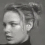 A grayscale four- shows a person with light hair in an updo, wearing a dark turtleneck, displaying three distinct facial expressions