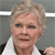 Static pixelated image of a person with short light brown hair wearing a white shirt with dark shoulder accents against a gray background with horizontal white lines.