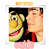 A square icon with a white border shows a person and a green puppet with a yellow nose, both smiling, with 'HEY THERE' text above and 'cutie' text below.