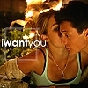 A static image shows two people in close physical proximity with a woman in a light green tank top and a man in a beige jacket, overlaid with white text reading 'iwantyou' against a blurred background.