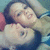 Pixelated image of two people in close embrace with one person's head resting on the other's shoulder, set against a blurred background.