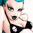 A pixelated cartoon character with blue hair and green eyes wearing a black bikini top with a white skull, next to green text reading "Original Icons .com" on a dark background.