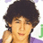 Pixelated image of a person with dark curly hair wearing purple, accompanied by repeated pink text and emoticons on white background.