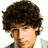 Pixelated close-up of a person with voluminous dark brown curly hair, light skin tone, and visible facial features including eyes, nose, mouth, and ear.