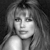 Black-and-white pixelated image of a person with long hair, shoulder-length bangs, and a neutral expression against a dark background.