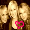 Three people with light brown hair pose closely together, one wearing a dark top with a pink heart outline over the chest area.