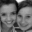 Two grayscale faces in close-up, side-by-side, with one face partially overlapping the other, both smiling with visible teeth.