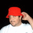 Pixelated image of a person wearing a red bucket hat and white shirt against a black background.