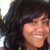 A person with dark wavy hair and light skin smiles broadly, showing white teeth in a of four where the rightmost is blank