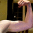 A muscular arm flexes in a bicep pose with hand clenched, set against a dark -patterned background