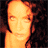 Pixelated static image of a person's face with warm orange and brown tones against dark background, appearing as low-resolution buddy icon.