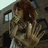 A pixelated image shows a person with brown hair holding a hand up, with orange text reading "I Think We Have An EMERGENCY" on a white and gray background.
