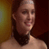 Static 49x49 pixel icon showing a close-up of a person's upper face and neck with dark hair, warm lighting, and blurred background colors.