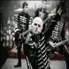 A 2x2 contact sheet of three animated frames showing a band performing on stage with black-and-white striped outfits and white hair, arranged in top-left, top-right, and bottom-left positions against a gray background.