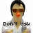 Pixelated image of a person with dark hair, red sunglasses, and an orange nose wearing a white shirt with black text reading "Don't ask".