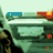 Animated sequence of two figures in dark clothing and sunglasses leaning forward on a motorcycle, with background elements shifting across frames.