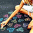 Pixelated image of a person in a white top and dark shorts lying on their side with one arm raised, surrounded by colorful abstract shapes.