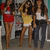 Three women pose in a ; the woman in the middle shifts her arm position between frames