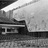Black-and-white pixelated image showing a stylized cinema building with a prominent marquee and a large light beam extending from the top left corner.