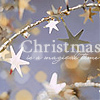 A static Christmas-themed icon with star-shaped ornaments on a branch, featuring partial text 'Christmas' and bokeh lights on a blue background.