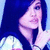 Pixelated image of a person with long dark hair, light skin tone, and pink lips holding a finger to their mouth in a shushing gesture against a blue background.