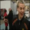 nine shows a person in a black jacket with red and yellow stripes, transitioning from smiling to shouting while standing in an indoor public space