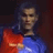 Pixelated static image of a person in sports attire with red and blue colors against dark background