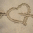 A split-screen image with a heart drawn in sand on the left and cyan text on a blue background on the right, stating 'LOVE is like the WIND I can't SEE it I can't TASTE it, but I can FEEL it, I KNOW it's THERE...'