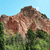 Pixelated landscape with brown rocky formations, green foliage, and a light blue sky background.
