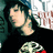 Pixelated image of a person with dark hair wearing black clothing, holding a colorful object against a blurred background.