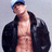 Pixelated image of a person with light skin wearing a dark jacket open over a bare chest, head tilted back, and a blue cap against a gray background.