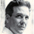 Pixelated grayscale portrait of a man with dark hair and neutral expression on light background.