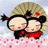 Two cartoon characters with large eyes and blonde hair embrace against a pink and white background with a black displaying text