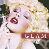 A static image of a woman with blonde curly hair, red lipstick, and a gold dress holding a microphone, with the word GLAM in white text on a maroon banner.