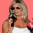 Static 48x48 pixel icon of a person with blonde hair holding a microphone against a solid pink background, rendered in low-resolution pixel art style.