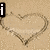A sand background with a heart drawn in the sand, displaying the words 'i', 'love', and 'you' in bold white text with black outlines.