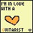 nine pixel-art icons with yellow backgrounds, each displaying 'I'M IN LOVE WITH A GUITARIST' text and an orange heart that changes shape across frames