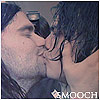 Two people in close physical contact with one person holding the other's face, text 'MOOCH' visible at bottom right.