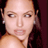 Pixelated close-up of a person's face with dark hair and earrings, visible shoulder, static image on dark background.