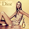 A woman in a light-colored sleeveless dress sits in shallow water with a bottle beside her, against a warm-toned background featuring the text "Dior".