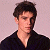 A pixelated image of a person with dark hair wearing a black shirt against a light background, next to green text on a dark green background.