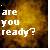Pixelated text reads 'are you ready?' in light-colored block letters against a blurred warm-toned background with yellow and brown hues.