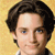 Pixelated portrait of a person with dark brown hair, light skin, and blue eyes against a yellow background.